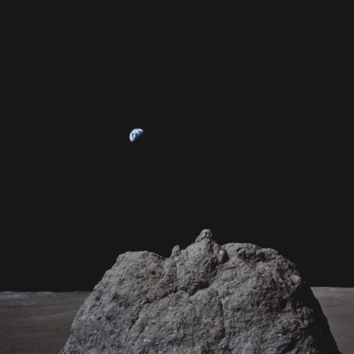 A rocky lunar surface with Earth visible in the dark sky, illustrating a breathtaking space view.