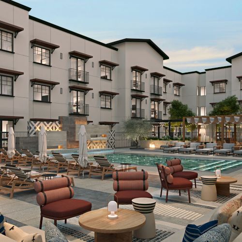 The image shows a modern outdoor pool area in a hotel courtyard with seating, umbrellas, and greenery against a multi-story building backdrop.