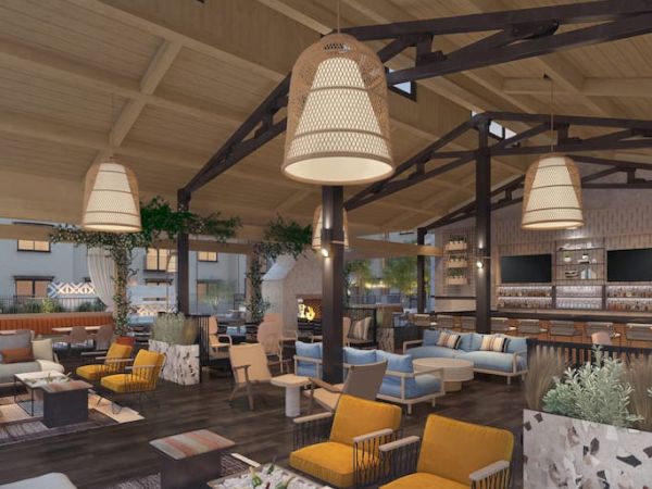 A modern lounge with cozy seating, warm lighting, and wooden accents. Features include a bar area and a fireplace.