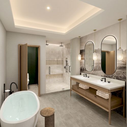 A modern bathroom with a freestanding tub, double vanity, backlit mirrors, walk-in shower, and warm, neutral colors.