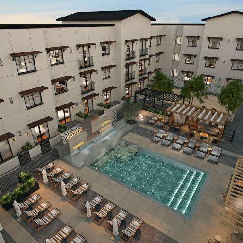 The image shows a modern hotel courtyard with a swimming pool, loungers, tables, and trees, framed by four-story buildings.