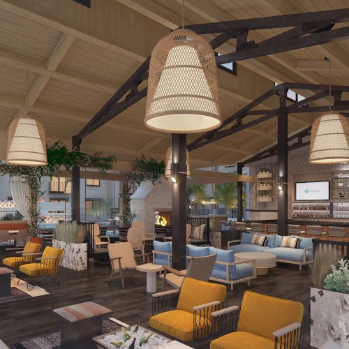 The image shows a modern, spacious lounge with wooden beams, cushioned seating, a fireplace, and large hanging lights.
