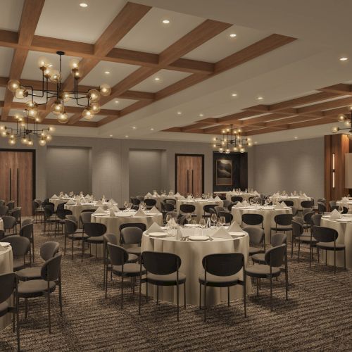 The image shows an elegantly set banquet hall with round tables, cushioned chairs, chandeliers, wood paneling, and framed artwork on the walls.