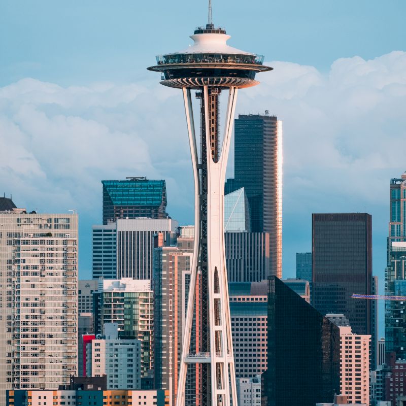 The image features a city skyline with a prominent tower structure in the foreground, surrounded by various buildings and skyscrapers.